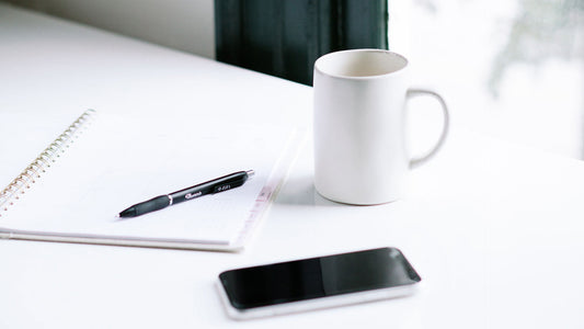 notepad, pen, coffee mug and phone